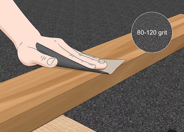 Dùng giấy nhám để đánh bóng bề mặt gỗ.